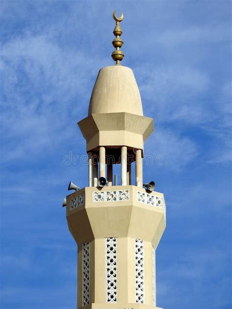 A High Minaret Of A Mosque Against A Lovely Blue Sky With Clouds At The