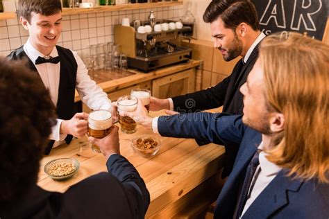 Hombres De Negocios Que Beben La Cerveza En Barra Imagen De Archivo