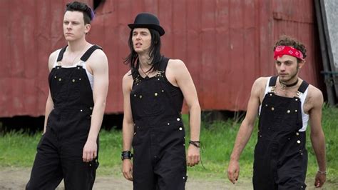 three men wearing black overalls and bandannas are standing in front of ...