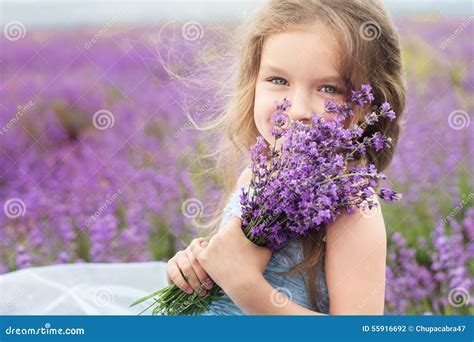 Petite Fille Heureuse Dans Le Domaine De Lavande Avec Le Bouquet Photo