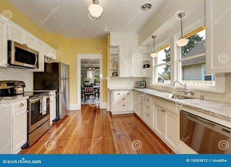 Kitchen Interior With White Cabinets Yellow Walls And Wood Floor Stock