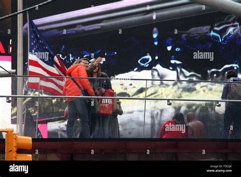 Young People Taking A Group Selfie Behind The American Flag In Times