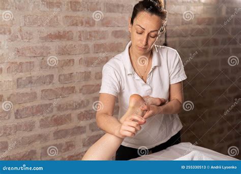 Doctor Masseur Making Manual Massage Of Feet For Lying Woman In