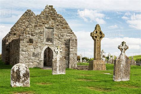 Ancient Stone Roofless Church With Celtic Crosses In A Grassy Field