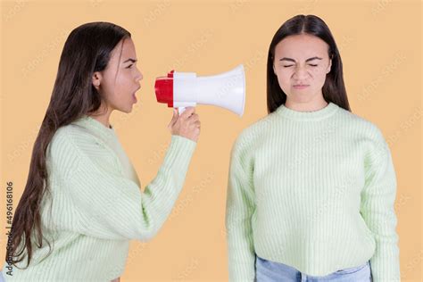 Emotional Woman Yelling At Her Twin Sister Using A Megaphone