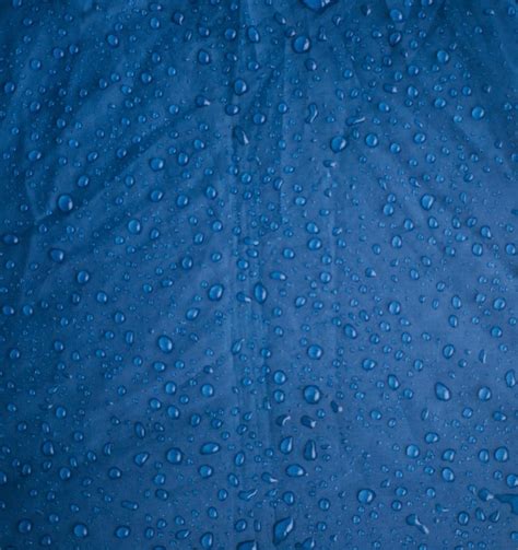 Gotas De Agua De Lluvia Sobre Un Fondo Azul Hecho De Tela Impermeable