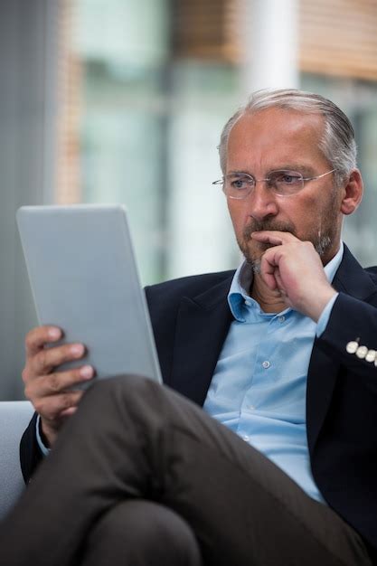 Premium Photo Thoughtful Businessman Holding A Digital Tablet