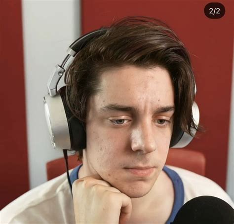 A Young Man Wearing Headphones Sitting In Front Of A Microphone And