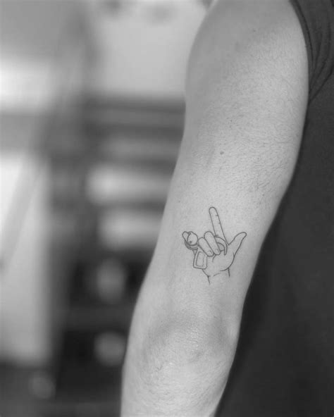 ILY sign tattoo located on Andrew Le Page's tricep.