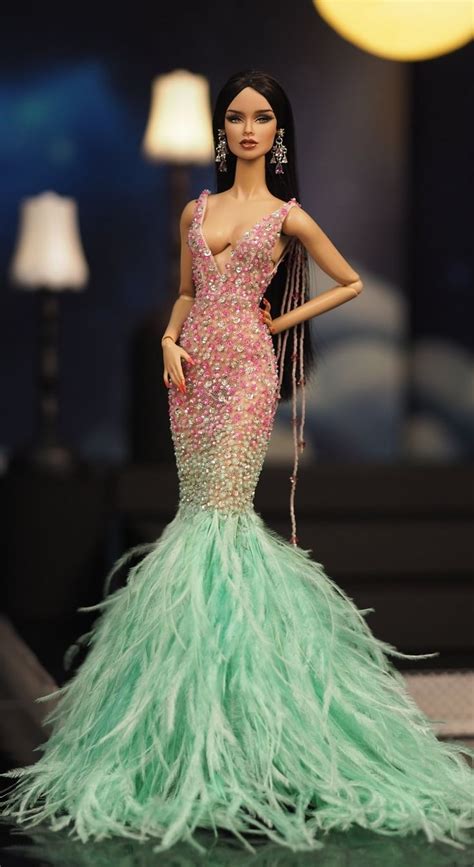 A Barbie Doll Dressed In A Green Feathered Dress And Holding A Chain