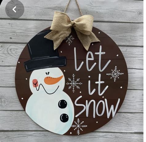 A Wooden Sign That Says Let It Snow With A Snowman Wearing A Top Hat