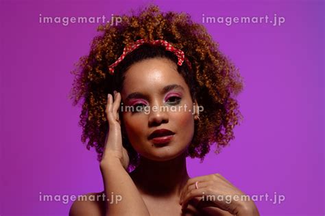 Biracial Woman With Pink Eye Shadow And Lipstick Touching Face Purple