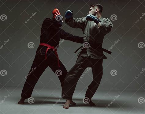 Fighting Guys During Mixed Fight Workout Athletic Males In Kimono And Boxing Gloves Training