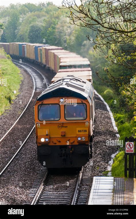 A Gbrf Class 66 Diesel Loco Heads A Westbound Freight Train Laden With Shipping Containers Near