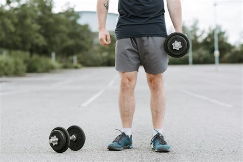 Strong Man Training With Dumbbells On Sports Ground · Free Stock Photo