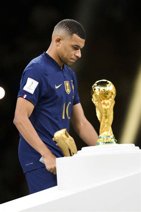 Photo : Kylian Mbappé passant devant le trophee de la coupe du monde ...