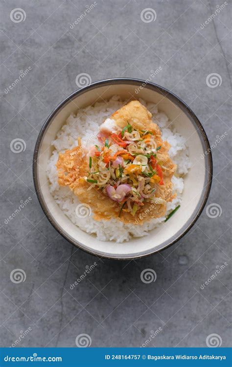 A Dish Of Rice Bowl With Crispy Fried Dory Fish And Indonesian Sambal