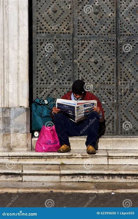 Homeless Man Reading Public Newspaper On The Stair Of The Walkway