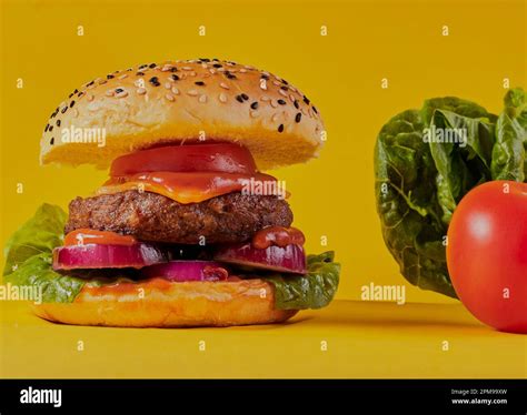 Cheese Burger In A Seeded Bun On A Yellow Background Stock Photo Alamy