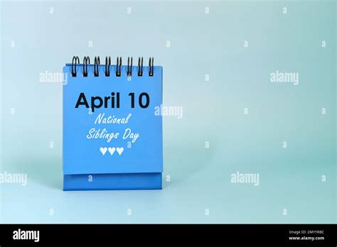 April As National Siblings Day Date Reminder On Blue Desk Calendar