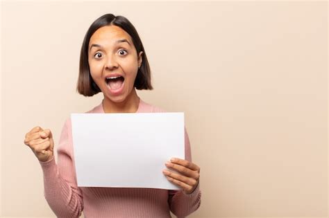 Mujer latina joven que se siente sorprendida emocionada y feliz riendo y celebrando el éxito