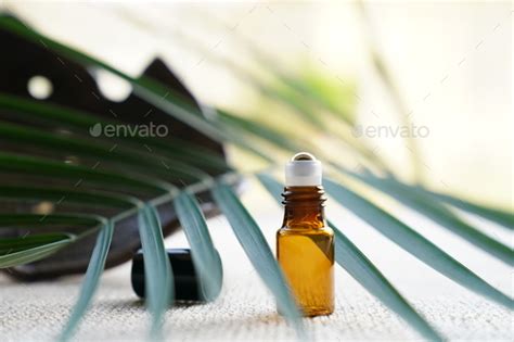 Blank Amber Glass Essential Oil Bottle On Tropical Leaf Background