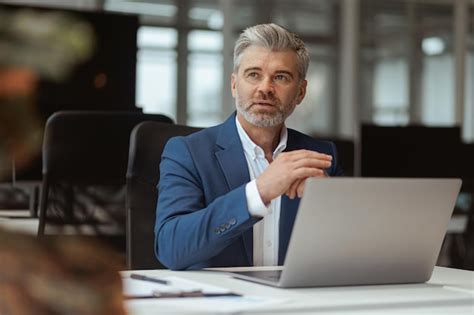 Premium Photo Busy Mature Businessman Workingon Laptop While Sitting