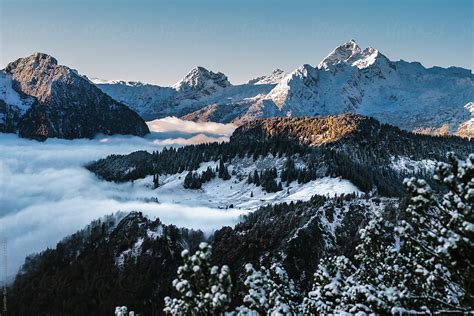 Fog Into Valley Surrounded By Snowcovered Mountain Landscape By