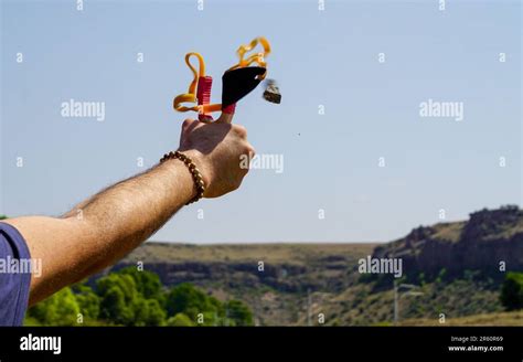 Man using spear thrower throwing rock nature amusement Stock Photo - Alamy