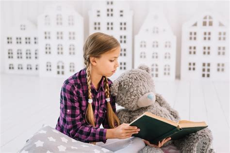 Ador Vel Menina Lendo Um Livro Seu Ursinho De Pel Cia Foto Gr Tis