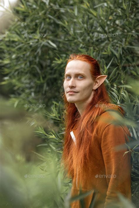 Artistic elf man with red hair and green eyes in the forest Stock Photo ...