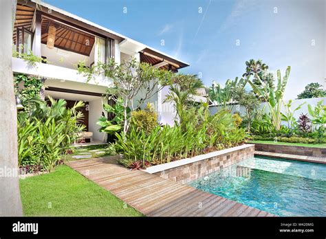 Luxury house with a swimming pool and a garden with lawn and trees ...