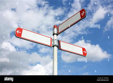 Blank Three Directional Road Signs In Red And White Against Blue Sky