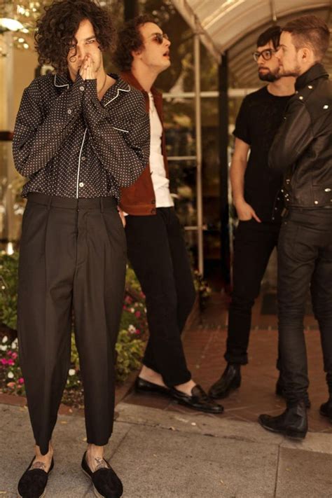 Three People Standing On The Sidewalk In Front Of A Building With One