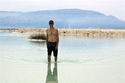 Mannen Ligger I Det D Da Havet Jordanien P En Bakgrund Fotografering