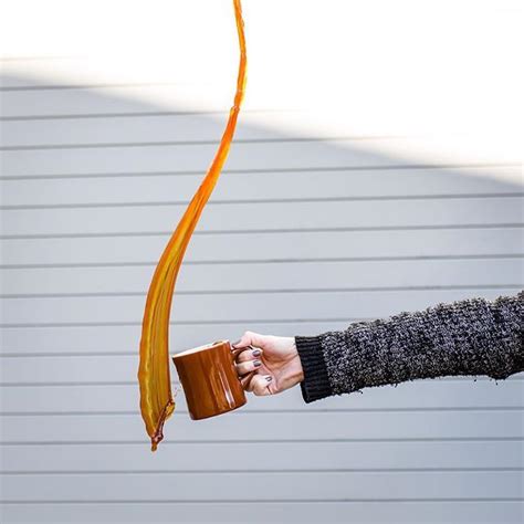 A Person Holding A Cup And A Long Orange Streamer In Their Hand With