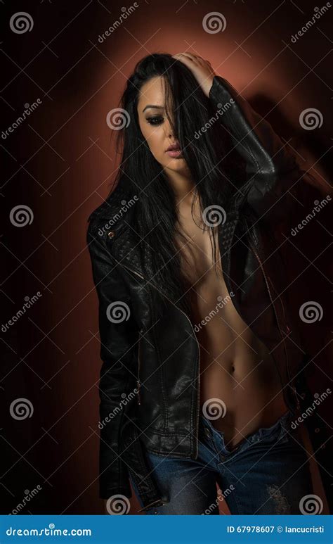 Attractive Brunette In Black Leather Jacket And Jeans Posing