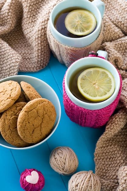 Dos tazas de té azules en suéter de punto con corazones de fieltro