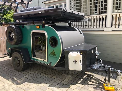 A Green And Black Trailer Parked In Front Of A House