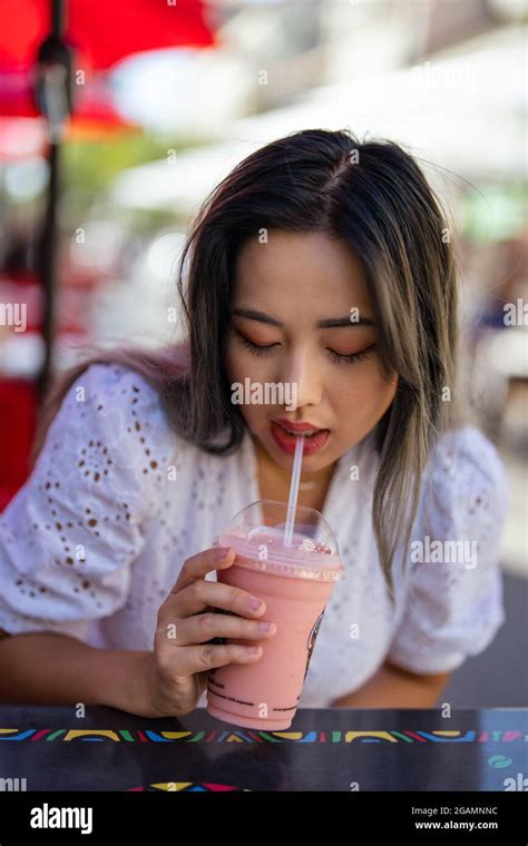 Beautiful Asian Woman Drinking A Strawberry Smoothie Stock Photo Alamy