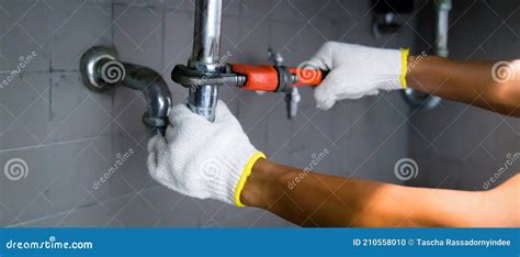 Close Up Of Male Plumber Fixing White Sink Pipe With Adjustable Wrench