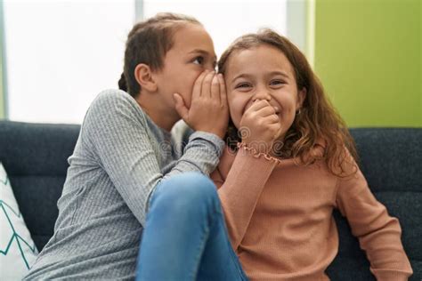 Two Kids Telling Secret Sitting On Sofa At Home Stock Photo Image Of