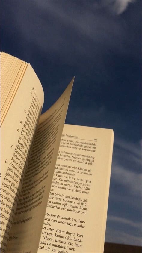 An Open Book Sitting On Top Of A Table Next To A Cloud Filled Blue Sky