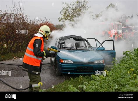 Feuerwehr Loescht Ein Brennendes Auto Verkehrsunfall Stock Photo Alamy