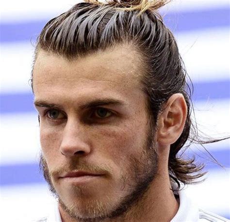 A Man With Long Hair And A Top Knot On His Head