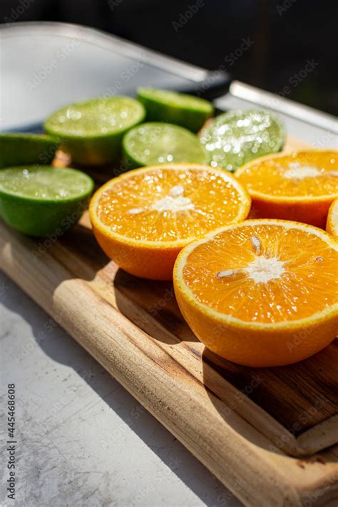 Naranjas y limones cortados por mitad sobre tabla de madera Stock Photo ...