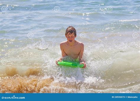 Muchacho Adolescente Que Practica Surf En Las Ondas Imagen De Archivo