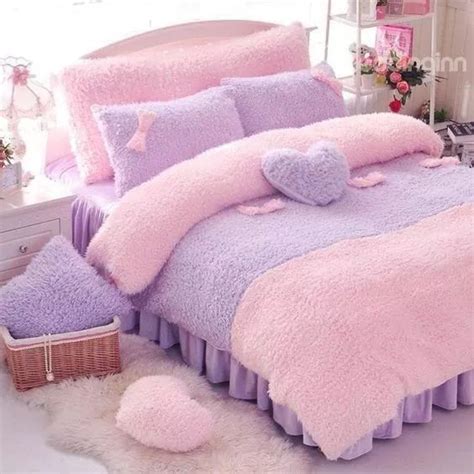 A Bed With Pink And Purple Comforters In A Bedroom Next To A Basket