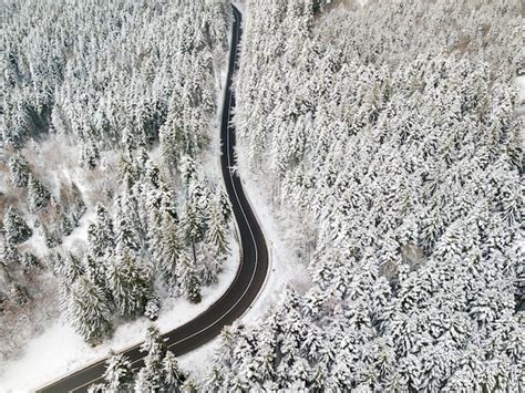 Premium Photo Aerial View Of A Snow Covered Forest Road