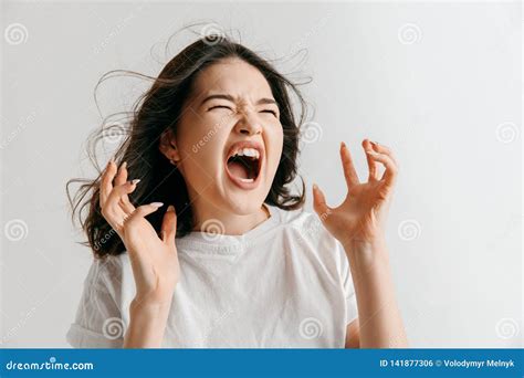 The Young Emotional Angry Woman Screaming On Gray Studio Background